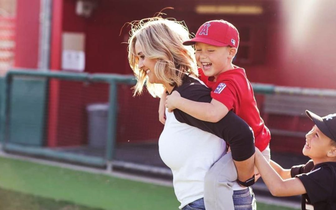 Sports mom carrying young athlete on back