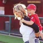 Sports mom carrying young athlete on back